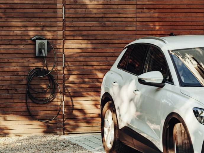 a white car parked in front of a wooden wall