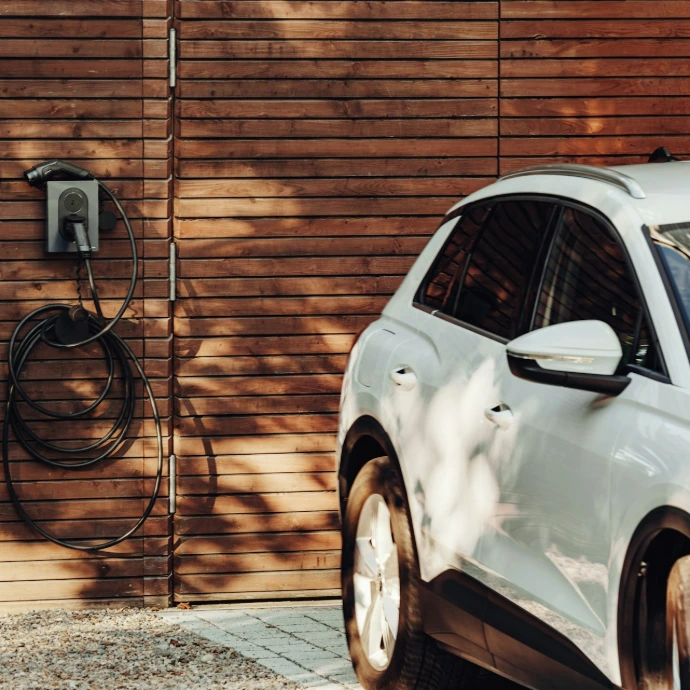 a white car parked in front of a wooden wall